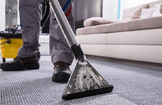 Professional worker vacuum cleaning carpet