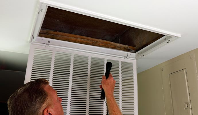 Worker inspecting air duct