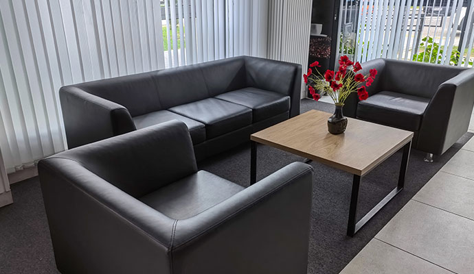 Black leather sofas sit in a lobby.