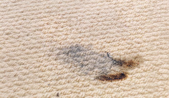 Carpet damaged by cigarette burn