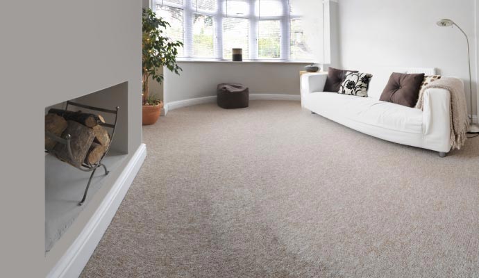 Clean living room with beige carpet and a white sofa