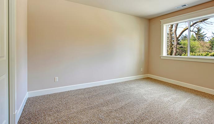 Clean and protected carpet in an empty beige walls room