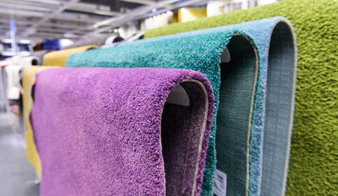 Colorful carpets hanging on shelves in a store