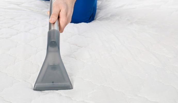 A person cleaning mattress