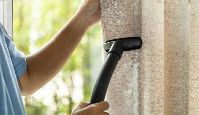 Professional man cleaning drapery