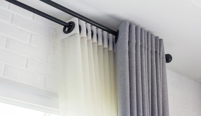 Double curtain rod set with eyelet style sheer and blackout curtains