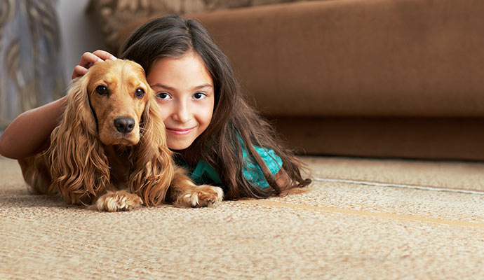Little girl with her pet on the carpet