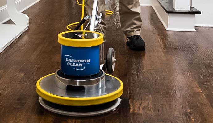 Dalworth Clean technician using a machine to clean hardwood floor