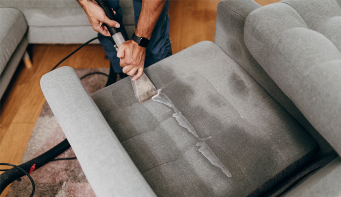 worker cleaning ottoman professionally