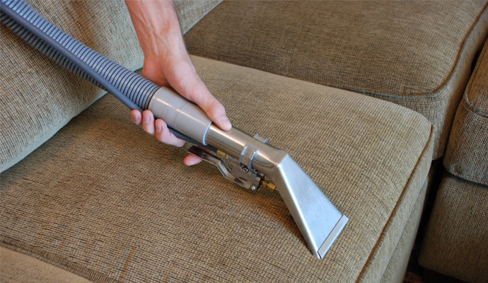 worker cleaning sofa