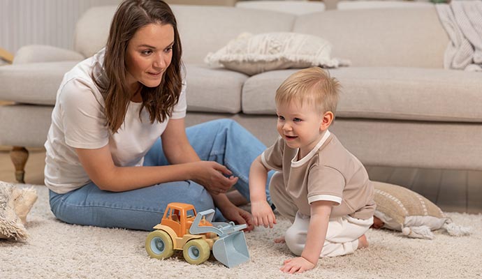 Mother and a baby playing on a clean carpet