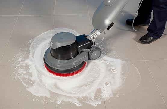 professional man cleaning tile floor with machine