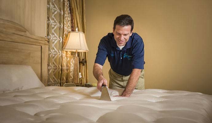 Dalworth Clean technician steam cleaning a mattress in a bedroom
