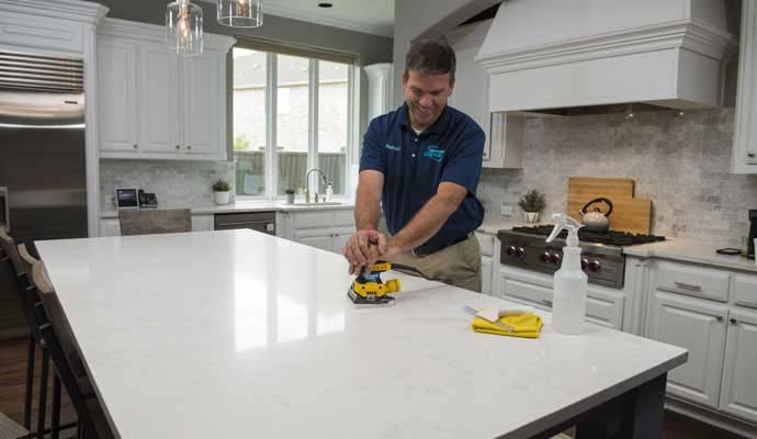 Dalworth Clean technician polishing a white stone kitchen countertop