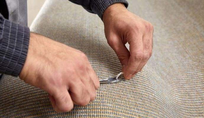 Technician repairing damaged fibers in a carpet