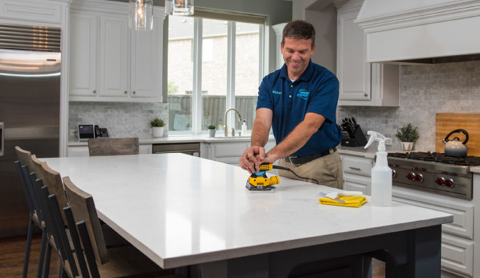 Technician sanding kitchen countertop