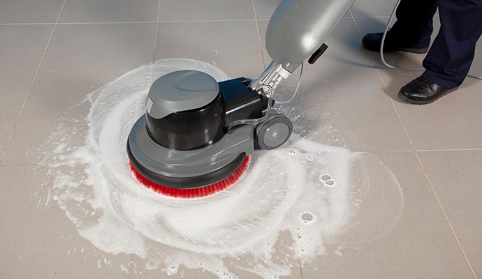 man cleaning tile and grout with machine