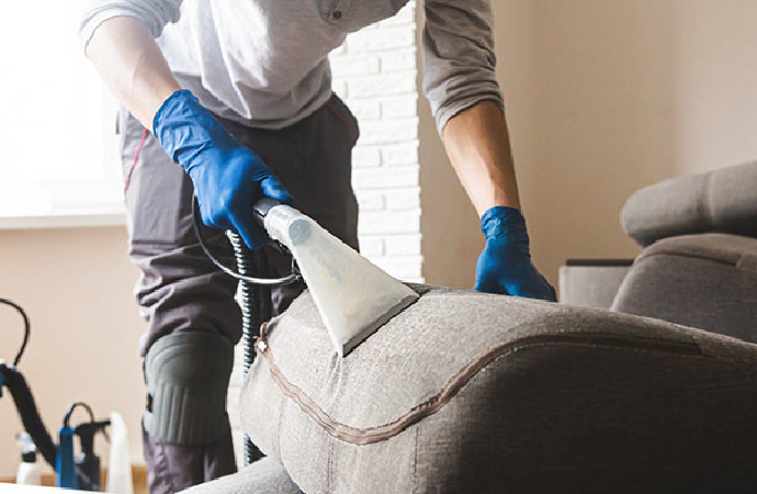 Worker cleaning sofa